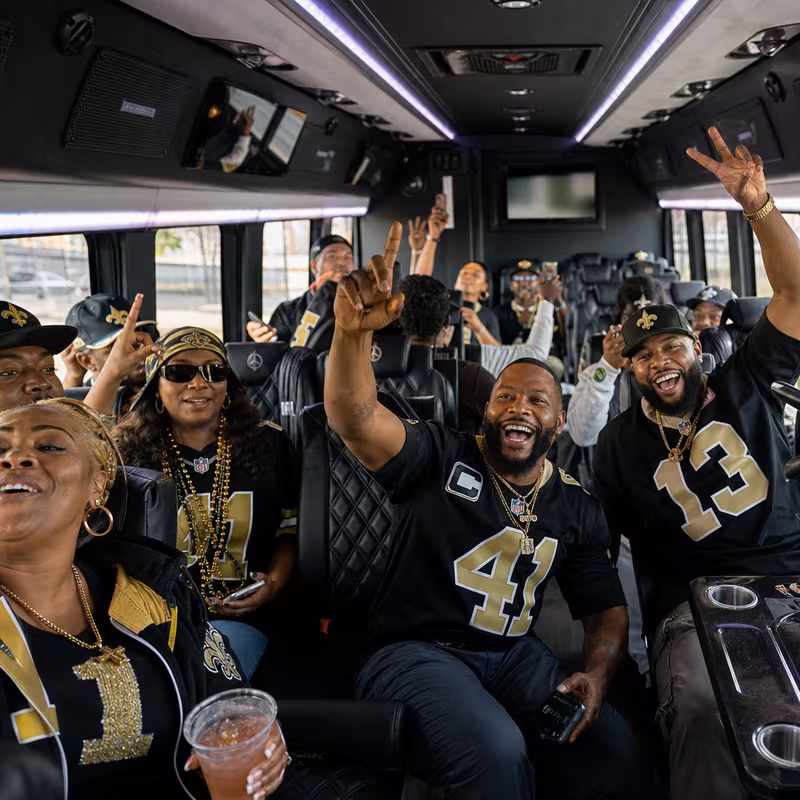 Group boarding a white charter bus for Sporting Event Transportation transportation in New Orleans